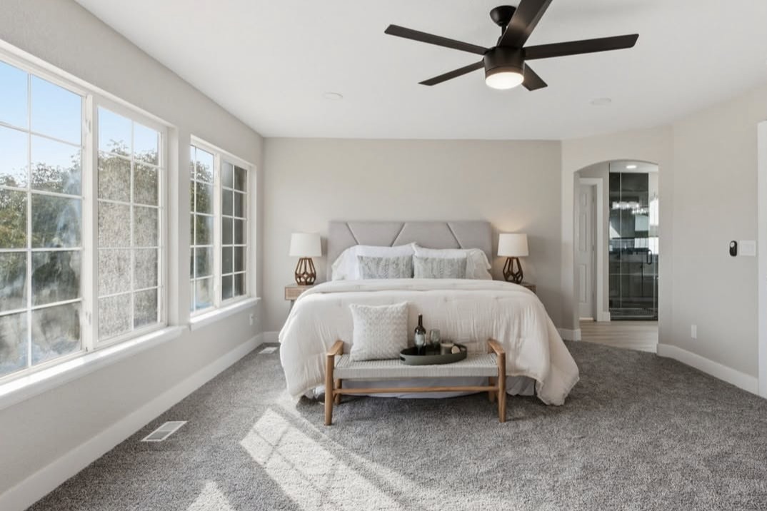 Bedroom with a ceiling fan, large windows and an ensuite bathroom