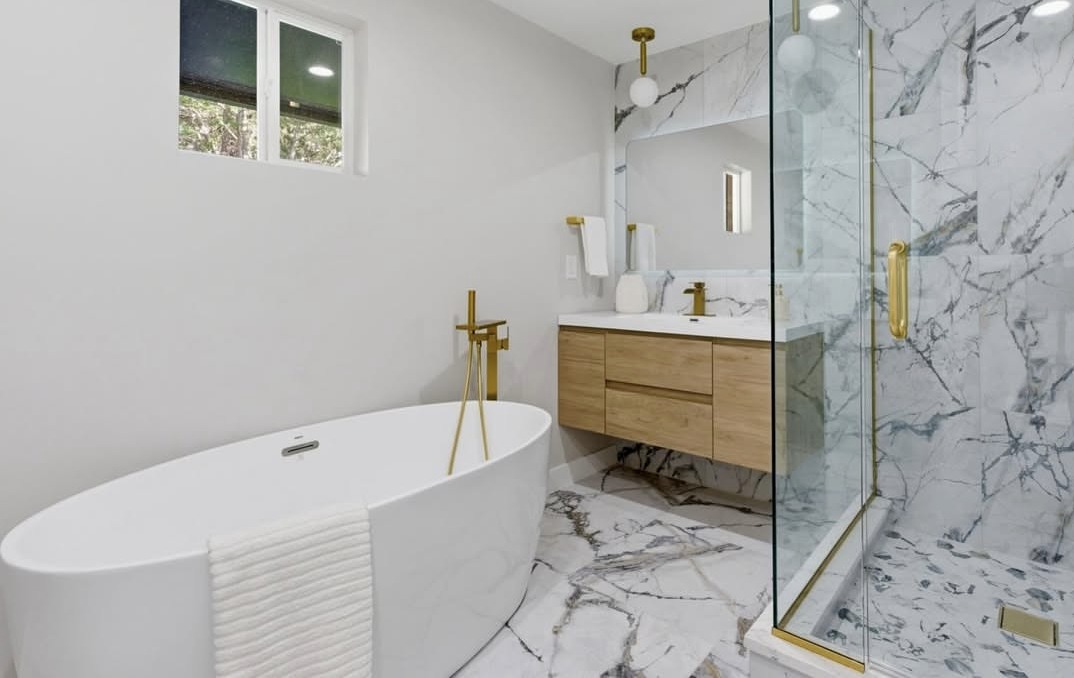 Marble bathroom with a freestanding tub and gold fixtures