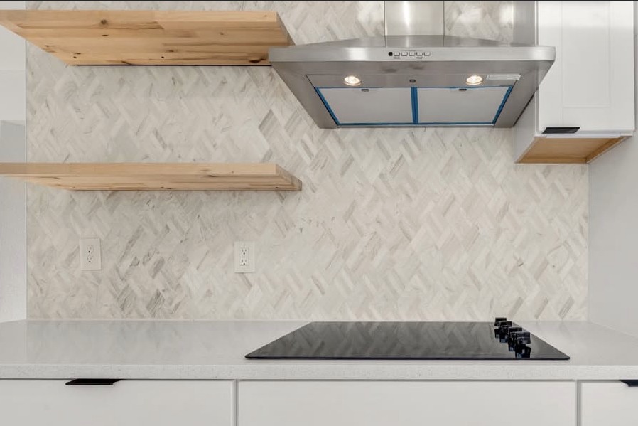 Kitchen with a herringbone backsplash and floating shelves
