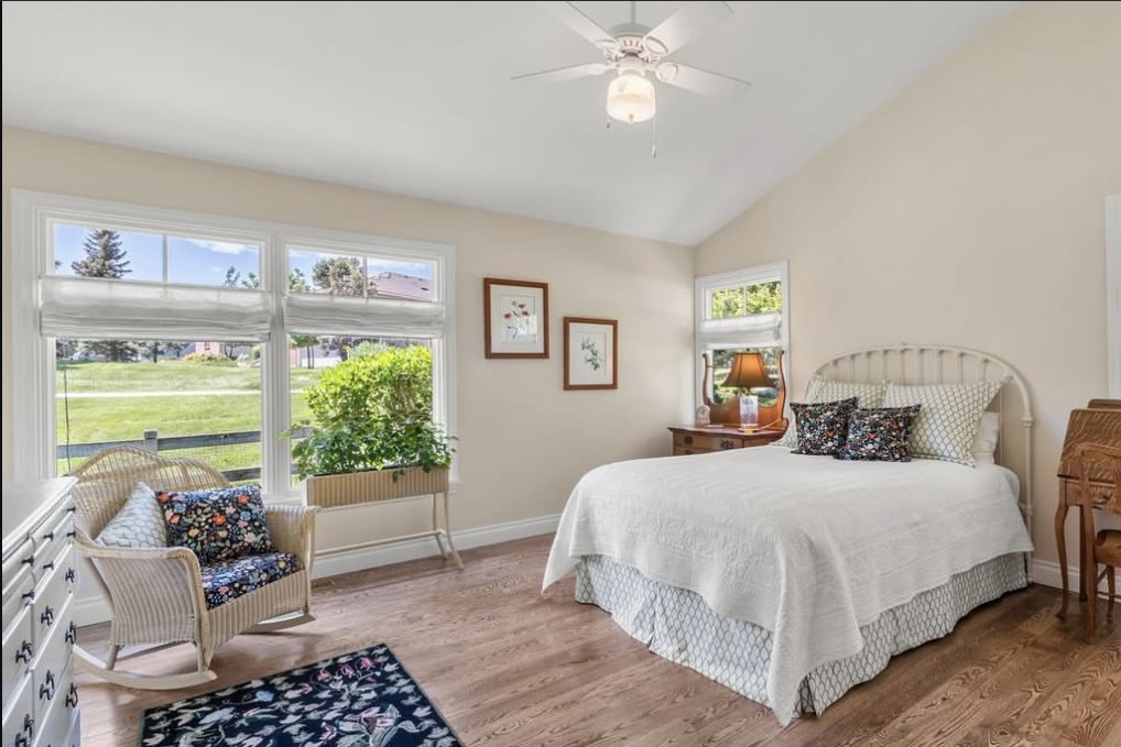 Vaulted guest bedroom with a white iron bed