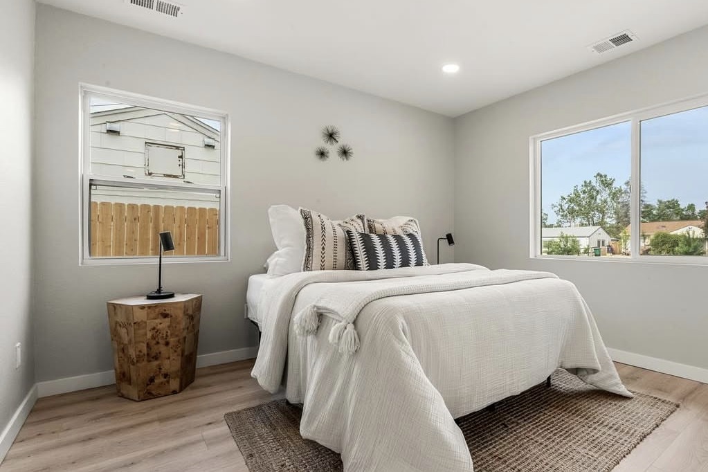 Bedroom with two windows and a burl nightstand