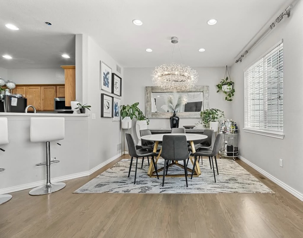 Dining room with crystal chandelier, round table and built-in shelving in Aurora, CO