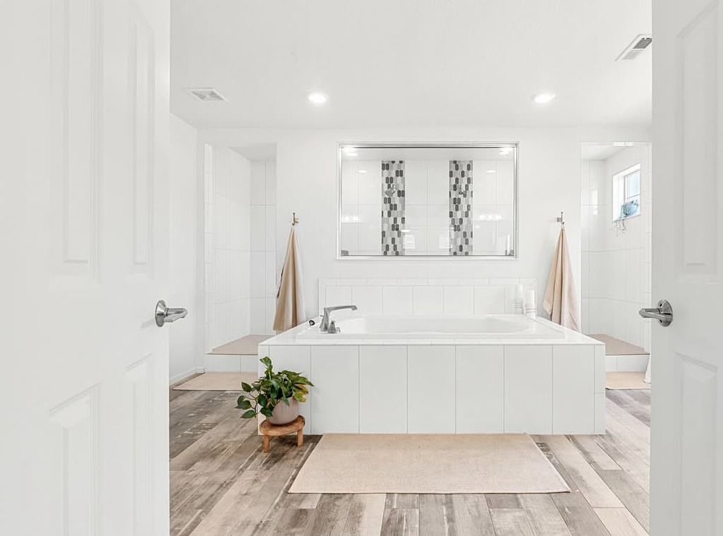 Primary bathroom with soaking tub framed by double doors in Aurora, CO