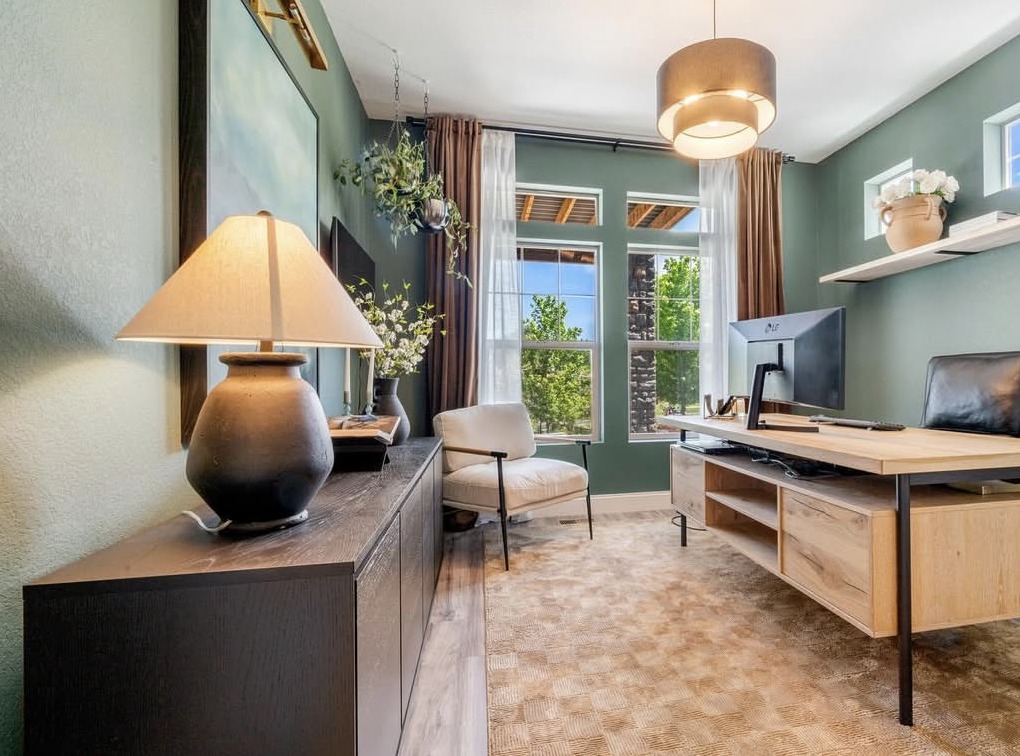 Sage green home office with oak desk and pendant light in Aurora, CO