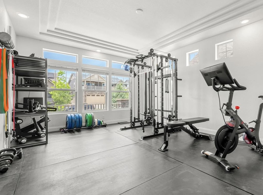 Home gym with large windows, cable rack and spin bike in Aurora, CO