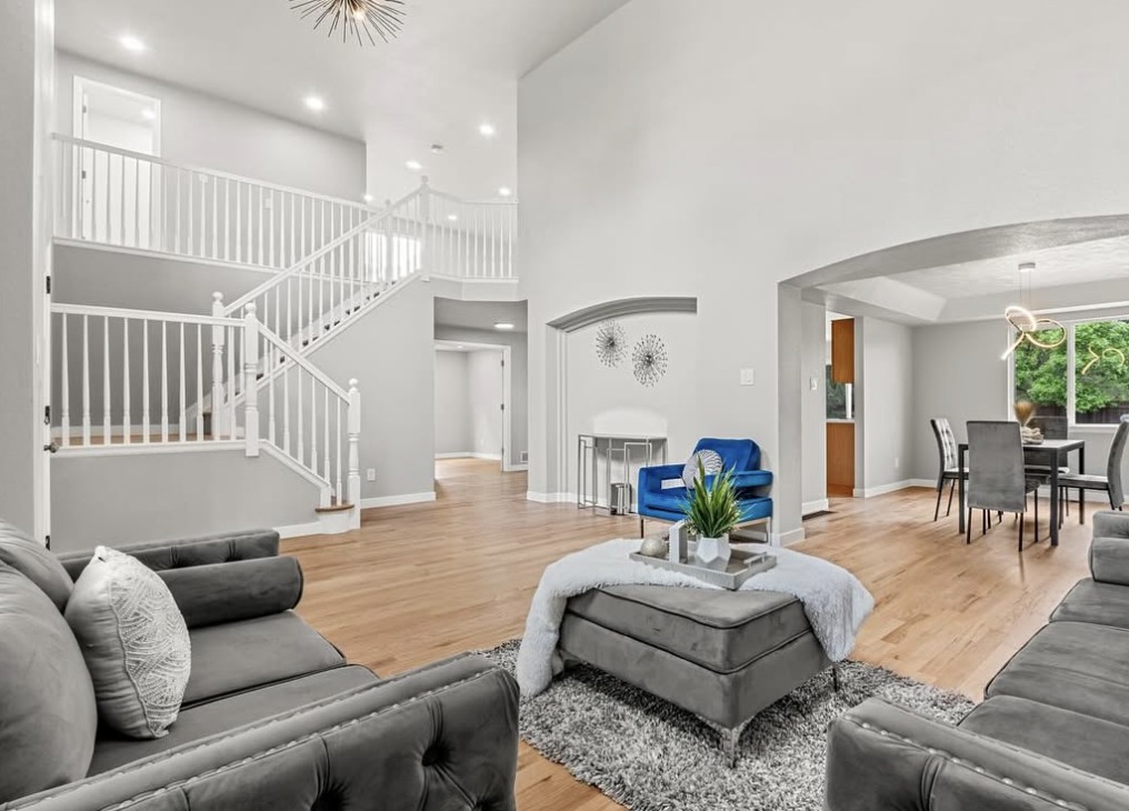 Two-story entry and living room with curved staircase and dining nook