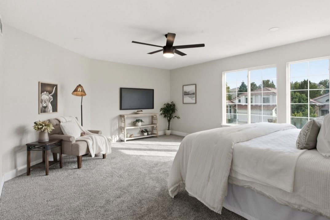 Large bedroom with a sitting area and window views