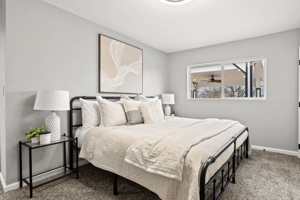 Bedroom with a black metal bed and large window