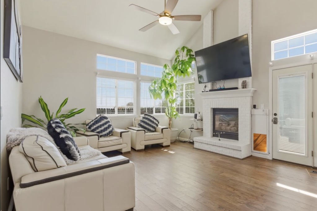 Vaulted living room with a white brick fireplace