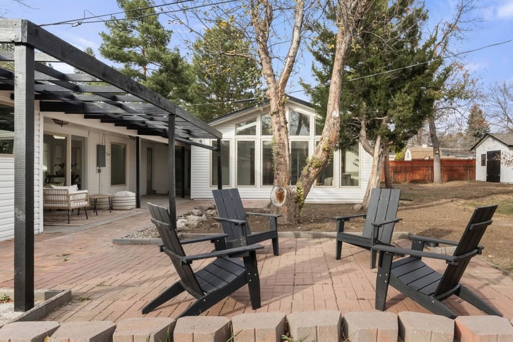 Backyard patio with a pergola and Adirondack chairs