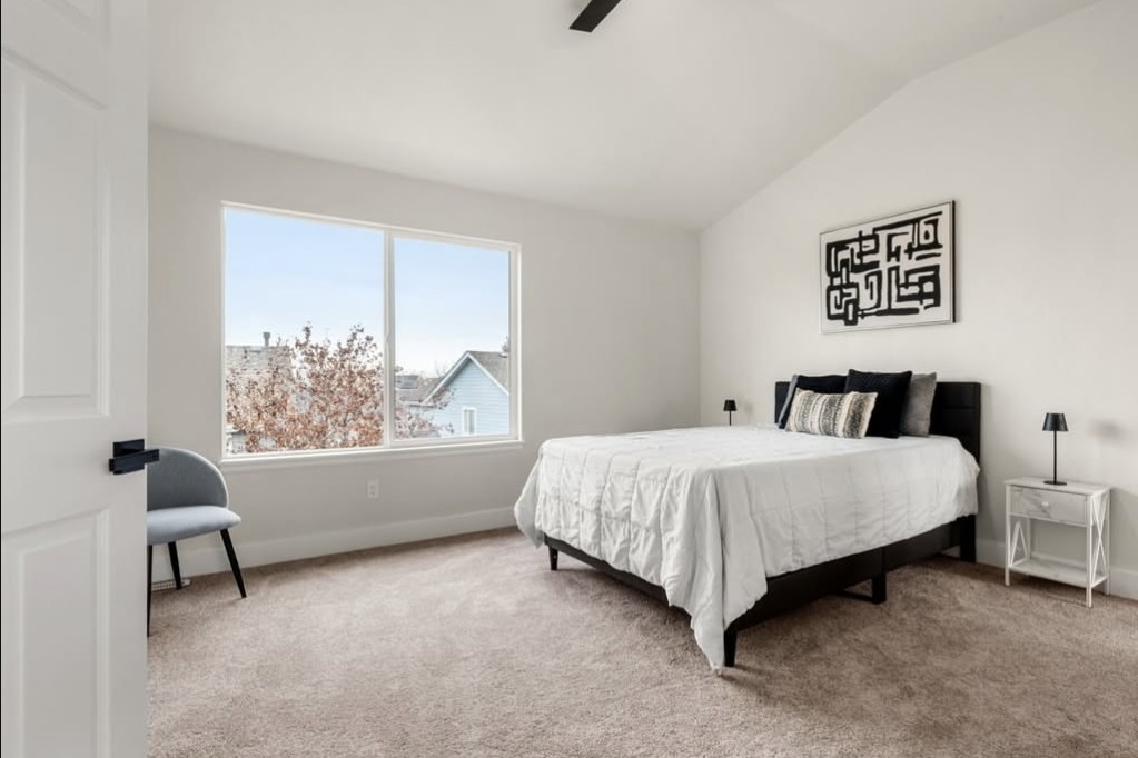 Bedroom with a vaulted ceiling and white bedding