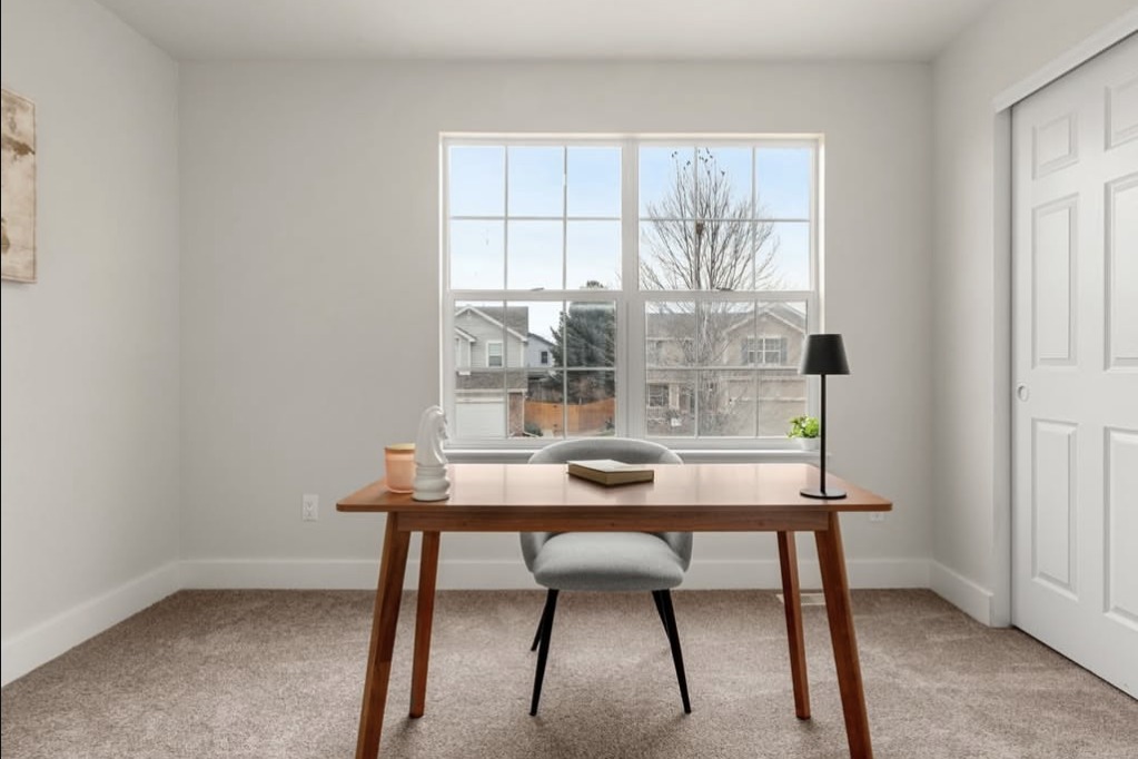 Home office with a wood desk and a large window