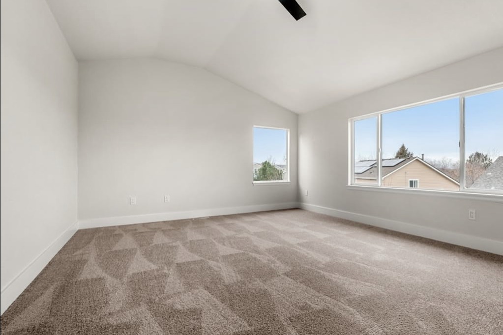 Empty vaulted bedroom with two windows
