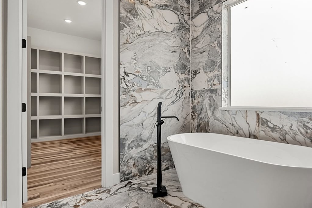 Marble bathroom with a freestanding tub and walk-in closet