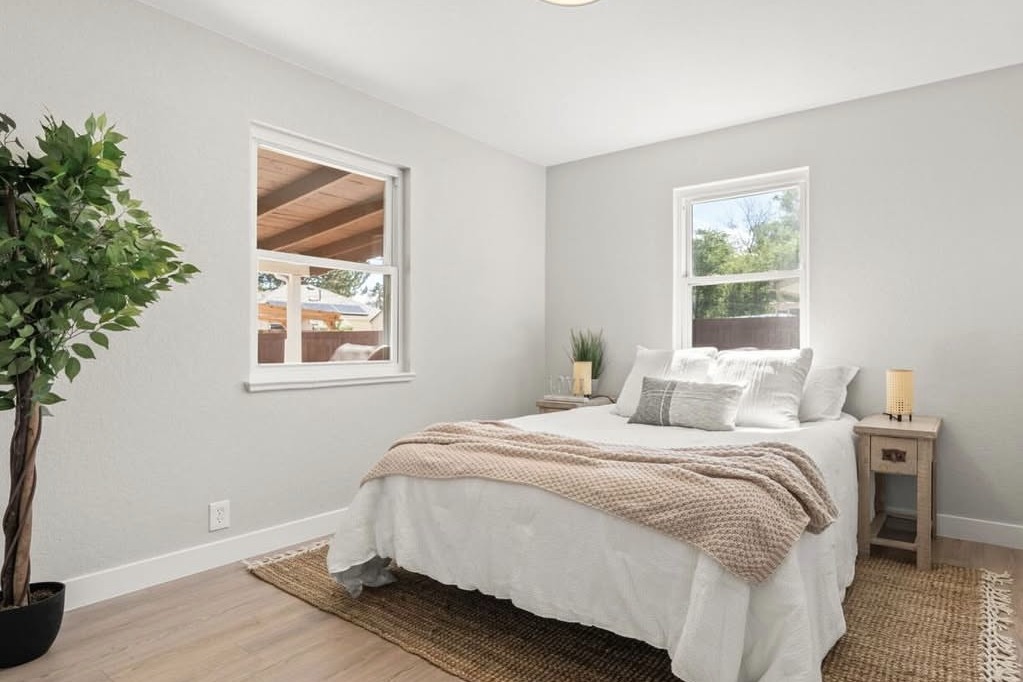 Bright bedroom with two windows and a jute rug