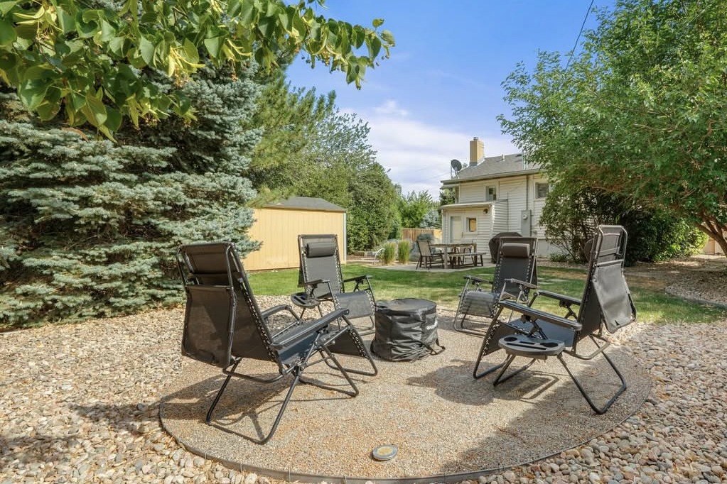 Backyard fire pit circle with lounge chairs