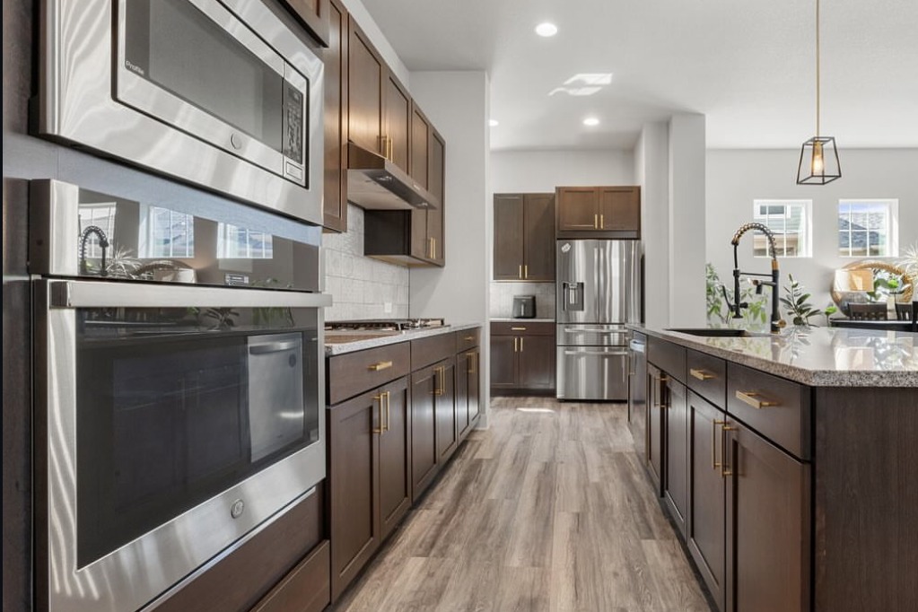 Kitchen with dark cabinets and stainless wall ovens